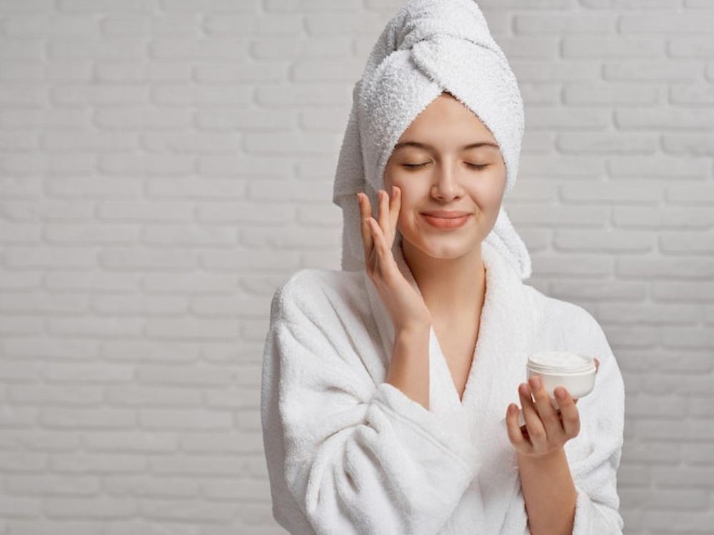Melhores Cremes para o Rosto Baratos: Hidratantes Faciais!imagem de uma mulher passando creme hidratante no rosto.