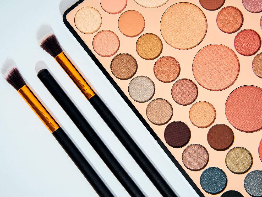 Melhores Paletas de Sombras Océane
imagem de uma paleta de sombras em tons quentes - pinceis de sombra ao lado