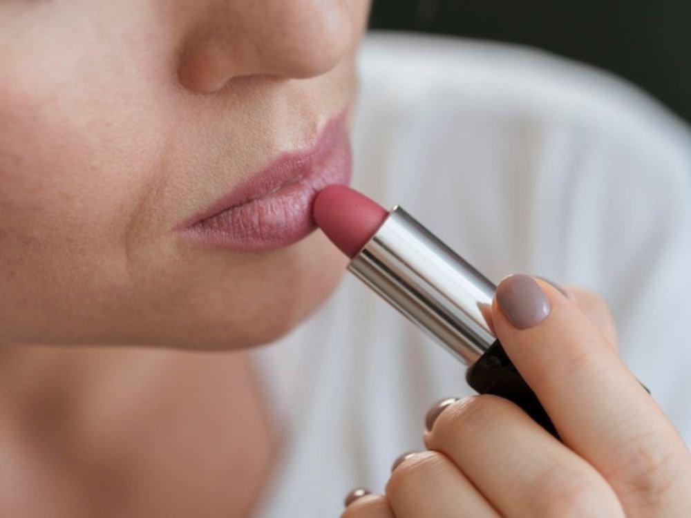 Melhores Batons Hidratantes imagem de mulher passando batom rosa